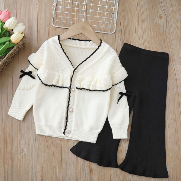 بنطلون أسود أنيق وبلوزة بيضاء ناعمة مزينة بخطوط سوداء خفيفة